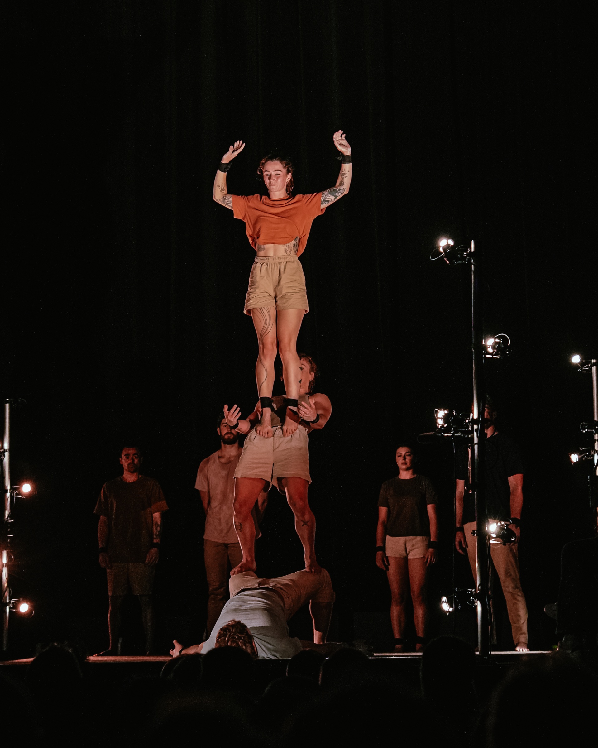Acrobate debout en équilibre sur les épaules de ses partenaires