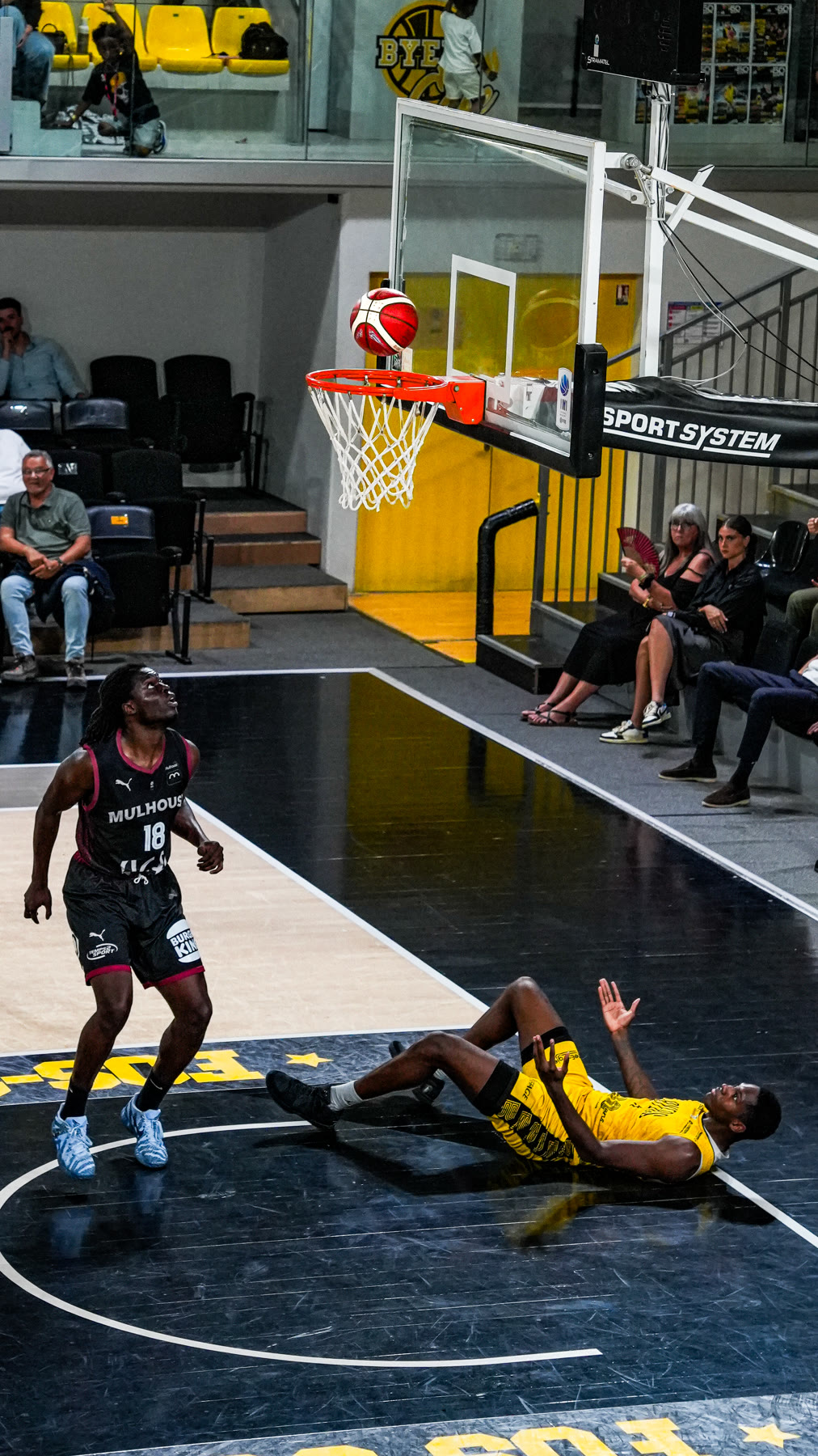 Ballon de basket au-dessus du panier pendant un match