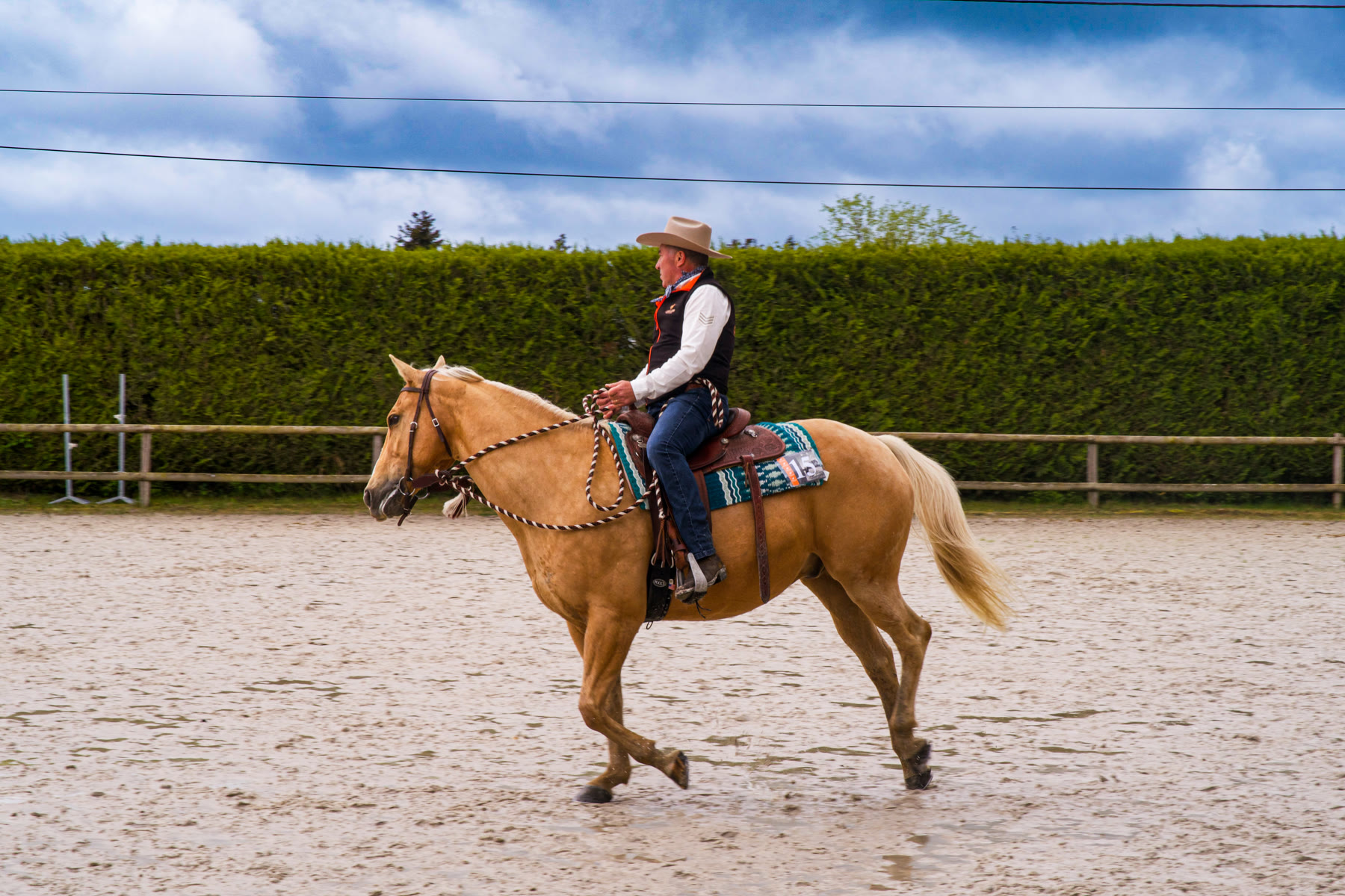 Cowboy à cheval dans une carrière