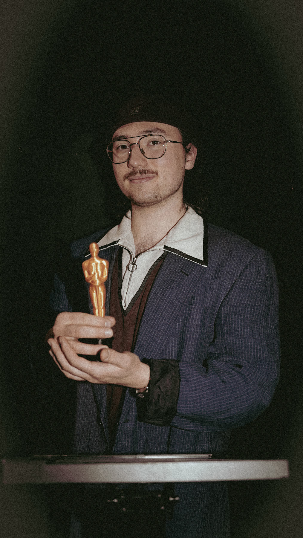 Portrait nocturne au flash avec une statuette dorée